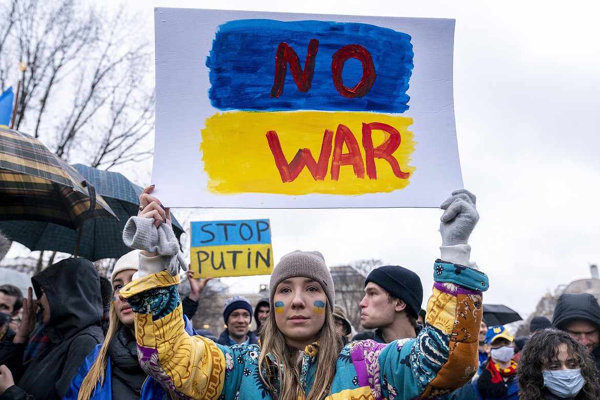 Ukrainian Oleksandra Yashan holds a sign that reads "No War" during a vigil to protest the Russian invasion of Ukraine in Lafayette Park in front of the White House in Washington, Thursday, Feb. 24, 2022. Ukrainians in the United States are praying for friends and family, donating money and supplies, and attending demonstrations.