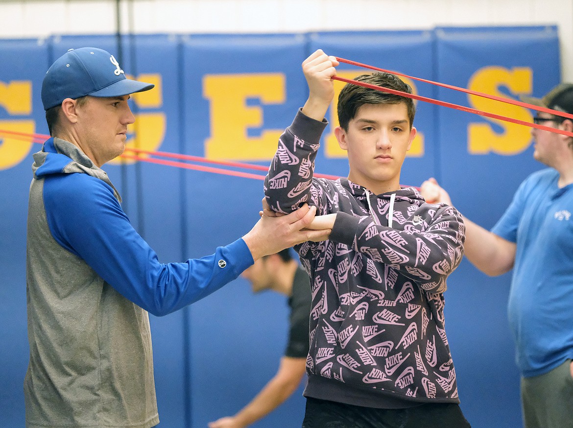 It doesn't look it outside, but spring is around the corner and the Libby Loggers American Legion Baseball program is getting ready. Coach Kelly Morford, left, works with Isaac Lamere on J-Band exercises during baseball practice on Feb. 21. (Paul Sievers/The Western News)