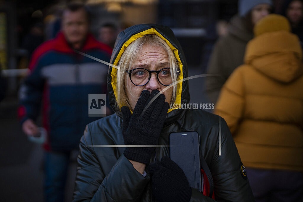A woman reacts to sirens sound announcing new attacks, outside a supermarket in central Kyiv, Ukraine, Monday, Feb. 28, 2022. President Vladimir Putin dramatically escalated East-West tensions by ordering Russian nuclear forces put on high alert following new crippling Western sanctions that forced his Central Bank to sharply raise its key rate Monday to save the ruble from collapse. (AP Photo/Emilio Morenatti)