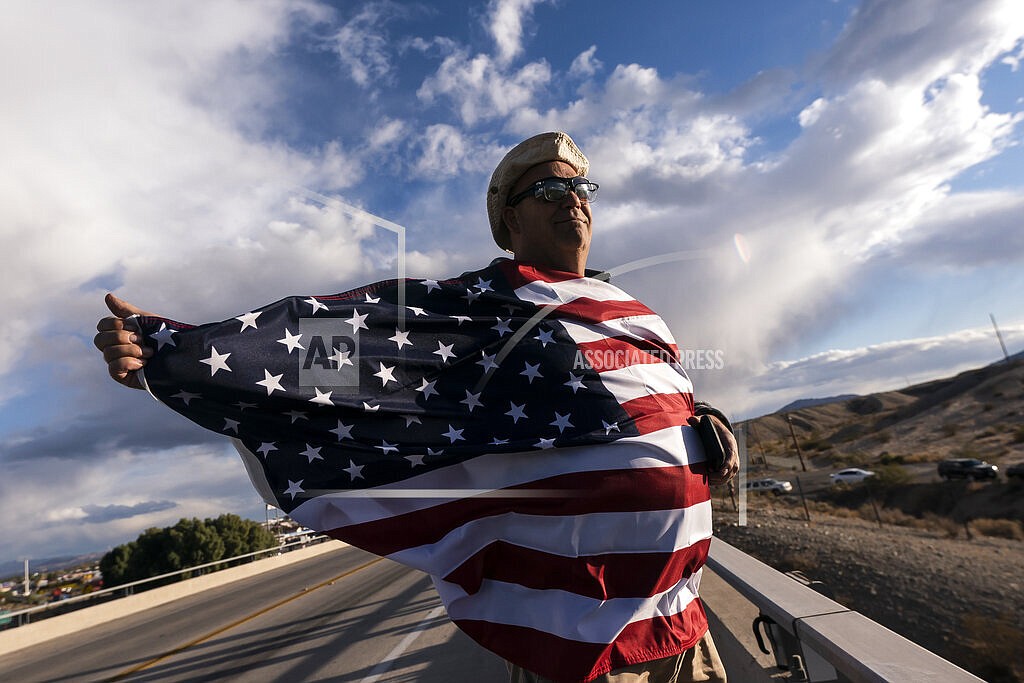 John Hiickman cheers on a convoy of truckers heading toward Washington to protest COVID-19 mandates, Feb. 23, 2022, in Needles, Calif. Omicron is fading away, and so are Americans’ worries about COVID-19. Fewer Americans now say they’re concerned they’ll be infected compared with January following the rise and fall of the wildly contagious coronavirus variant. That's according to a new poll from The Associated Press-NORC Center for Public Affairs Research. (AP Photo/Nathan Howard, File)