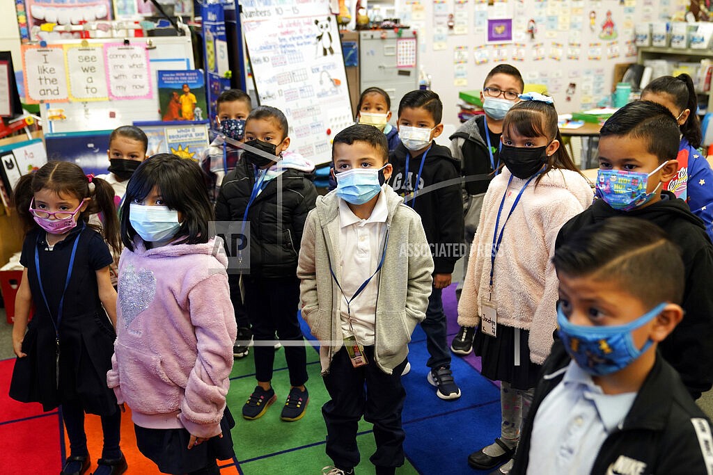 Kindergarteners wear masks while listening to their teacher amid the COVID-19 pandemic at Washington Elementary School on Jan. 12, 2022, in Lynwood, Calif. The governors of California, Oregon and Washington have announced that schoolchildren will no longer required to wear masks starting March 12, 2022. The governors of the three states announced the measure in a joint statement as part of new indoor mask policies that come as coronavirus case and hospitalization rates decline across the West Coast. (AP Photo/Marcio Jose Sanchez, File)