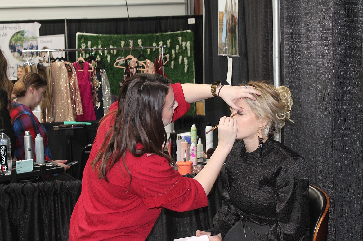 Kellsi Foster prepares Amy Kovaleva’s makeup for the fashion show at the Enchanting Bridal Show Saturday.