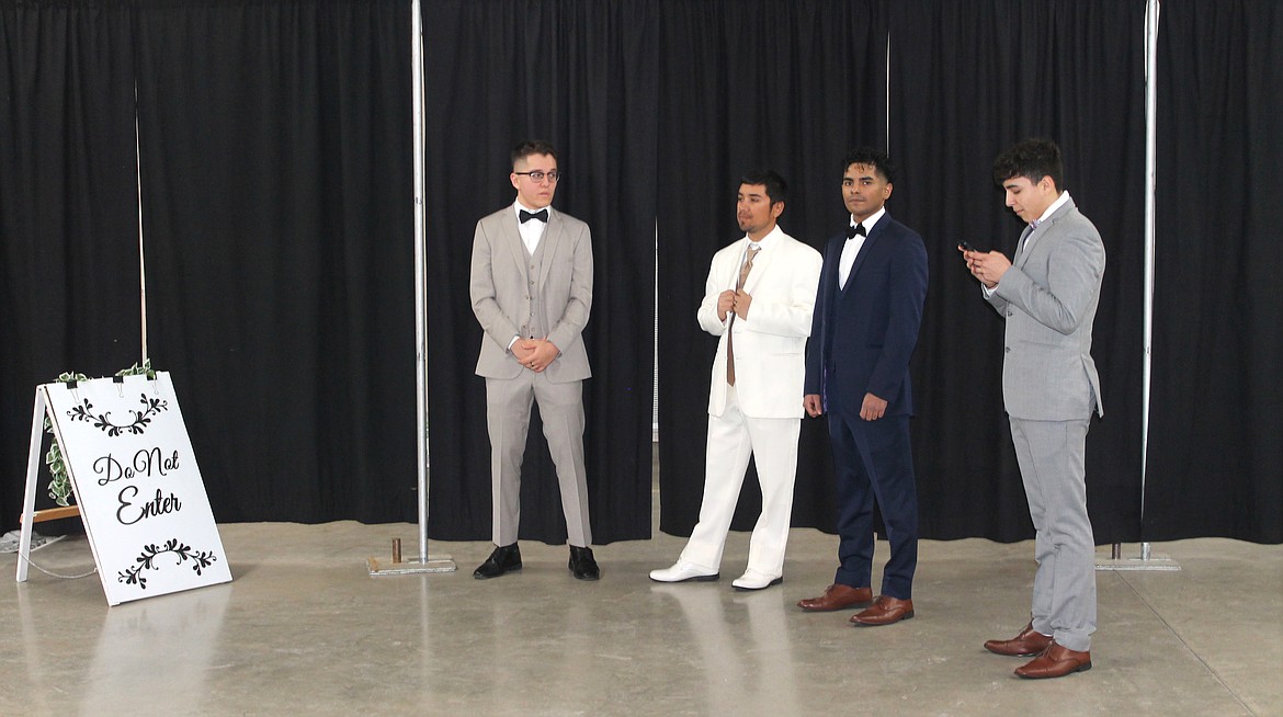 From left: John Lopez, Gary Candela, Jose Chavez and Isaiah Patero wait their turn to show off formal wear in the fashion show at the Enchanting Bridal Show Saturday.