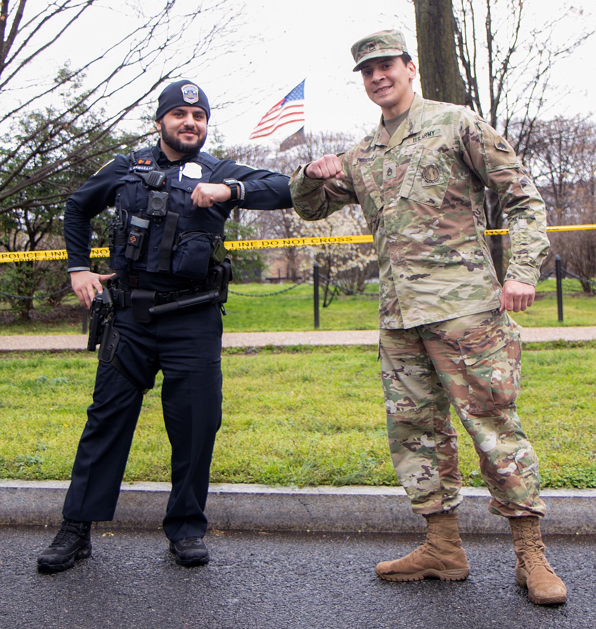 Then-Army National Guard Staff Sgt. Andrew Enriquez, right, bumps elbows with Officer Imar Samaraay, 7th District D.C. Metro Police Department while patrolling the tidal basin along the National Mall. The basin, a popular destination for viewing of the spring cherry blossoms, had been restricted due to the early stages of the coronavirus pandemic. Photo by Army National Guard Sgt. John Stephens