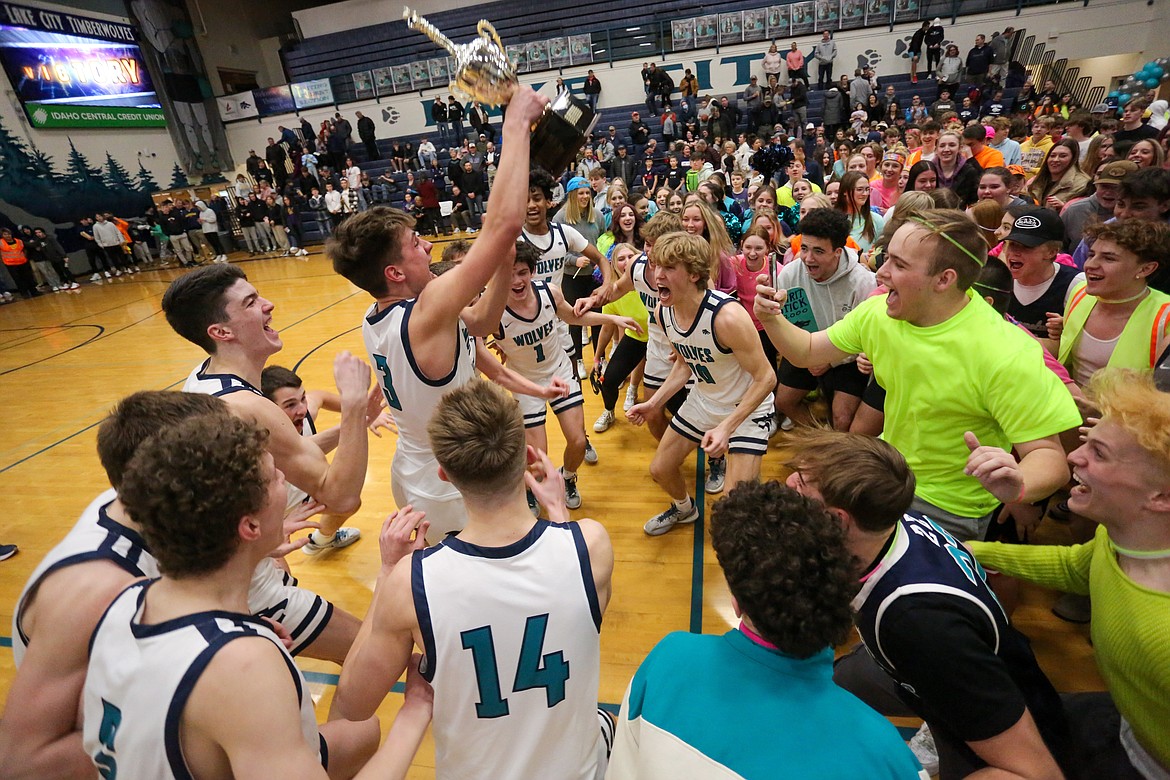 JASON DUCHOW PHOTOGRAPHY
Lake City High players show a little more emotion as senior Miles Jones holds up the trophy after the Timberwolves won the 5A Region 1 boys basketball title last week.