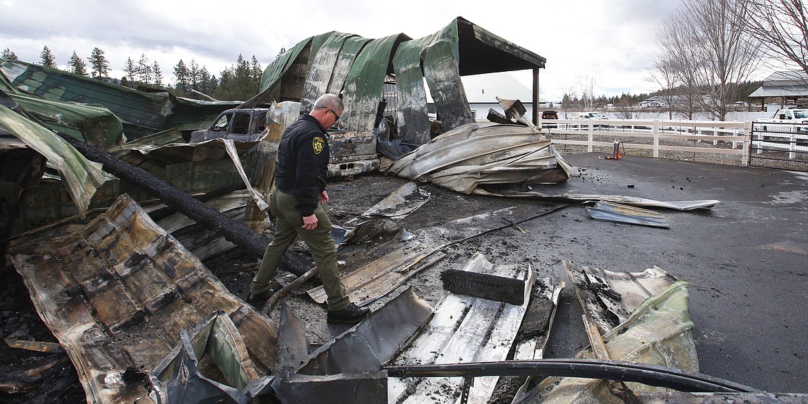 Sheriff Bob Norris looks over the scene of a fire and deadly shooting at Hauser Lake. BILL BULEY/Press