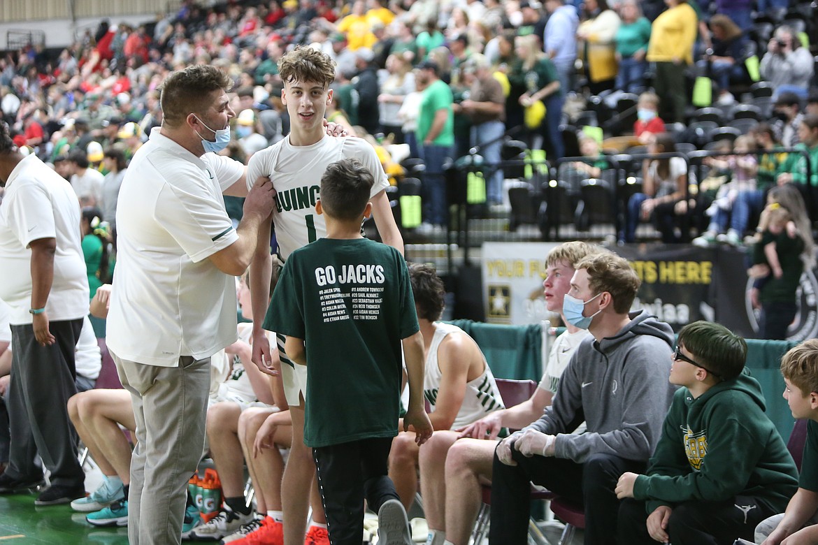 Quincy guard TreyVaughn Bierlink is congratulated by his father and team head coach, Scott Bierlink, after the Jacks’ win.