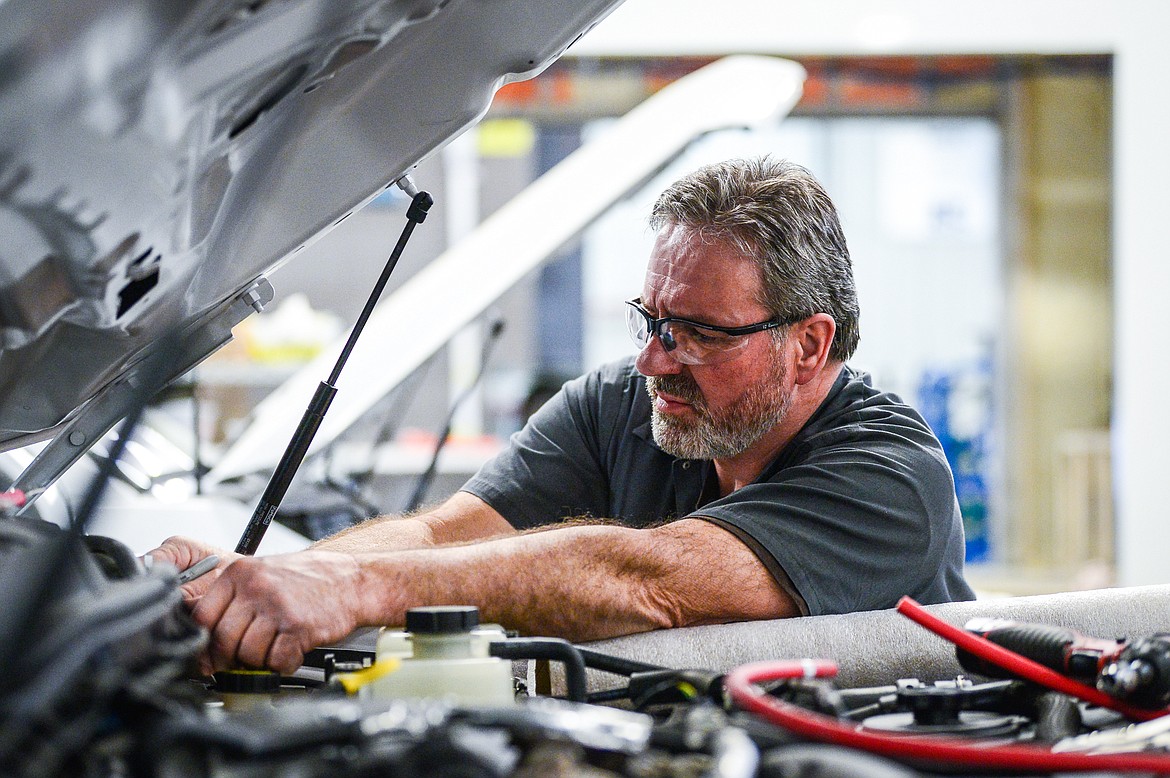 Don Hunt works on wiring a tactical command vehicle's system of batteries at Nomad Global Communication Solutions on Wednesday, March 2. (Casey Kreider/Daily Inter Lake)