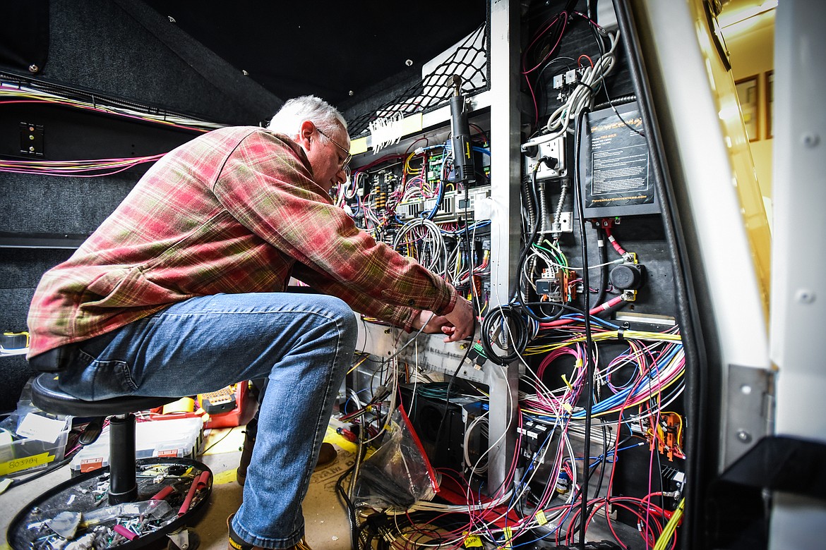Jim Fabricius works on the wiring inside a tactical command vehicle at Nomad Global Communication Solutions on Wednesday, March 2. (Casey Kreider/Daily Inter Lake)