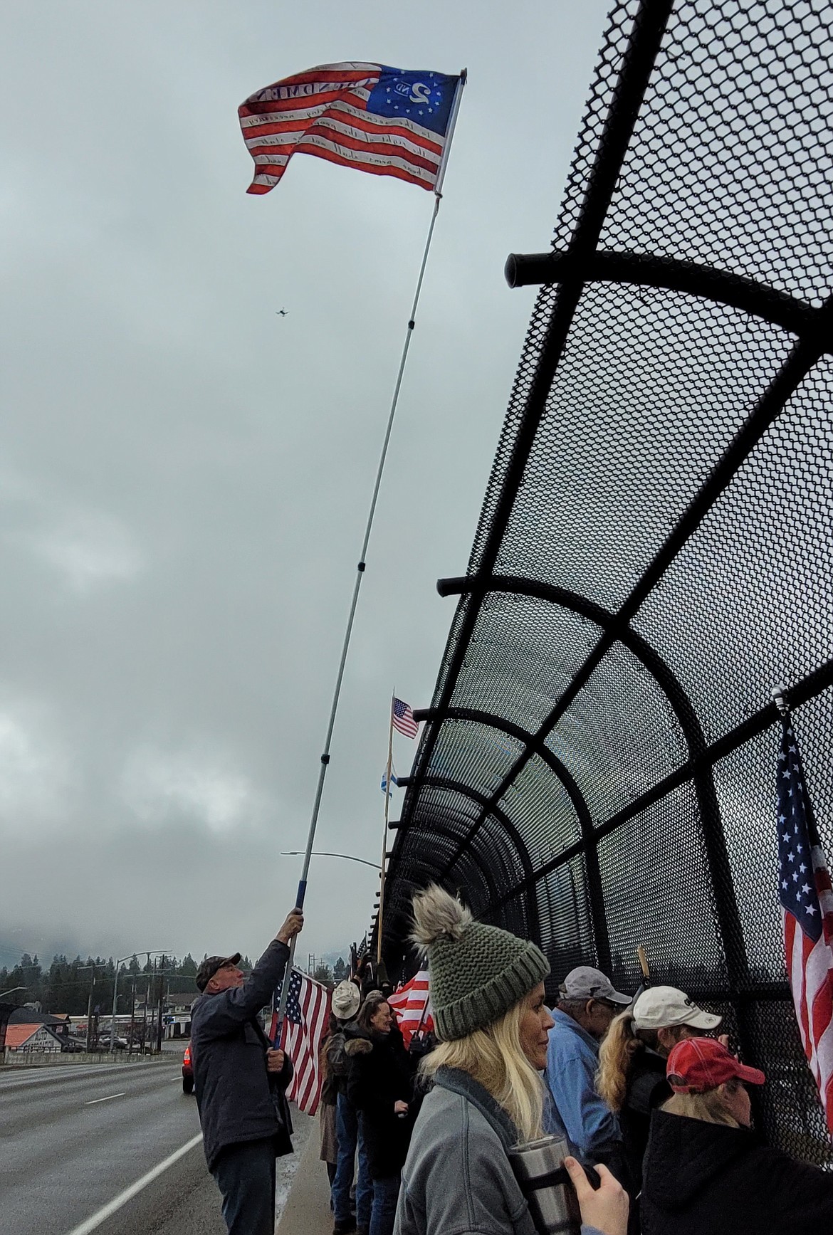 Nolan Gaul uses a 24-foot pole to wave a Second Amendment American flag over the Greensferry overpass in Post Falls.