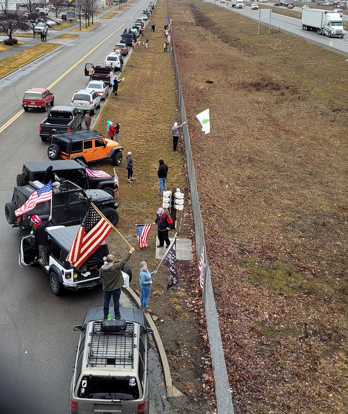 People lined up along I-90 on Wednesday morning to salute the American Freedom Convoy on its way to the nation's capital to protest COVID-19 mandates.