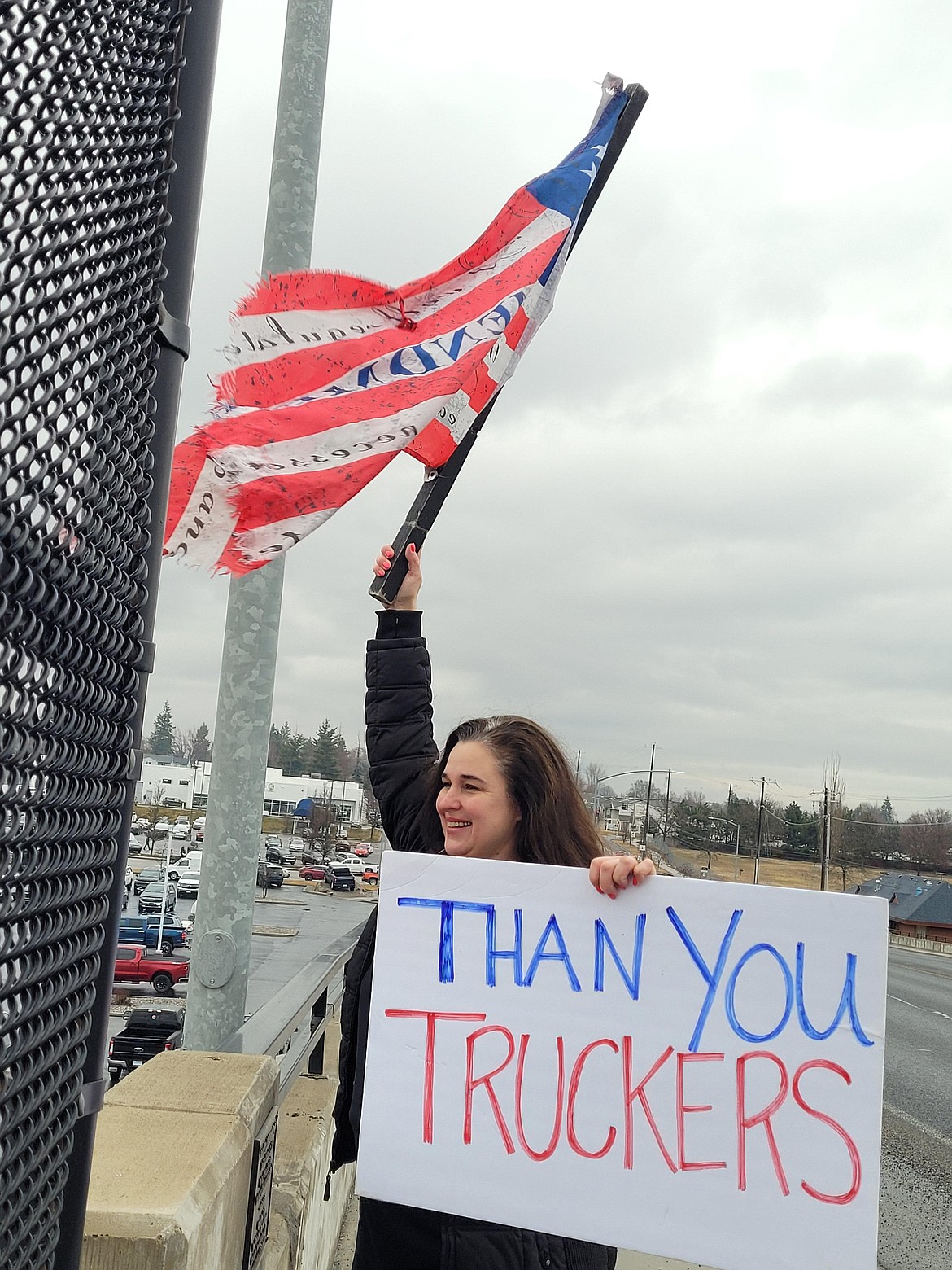 Kimberly Cloward of Rathdrum waves a worn Second Amendment American flag on an overpass Wednesday.