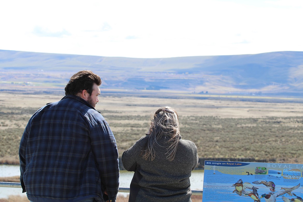 Kyle (left) and Corday Wilkinson, of Spokane, scan for birds at the Royal Lake Overlook near Othello in March 2021.