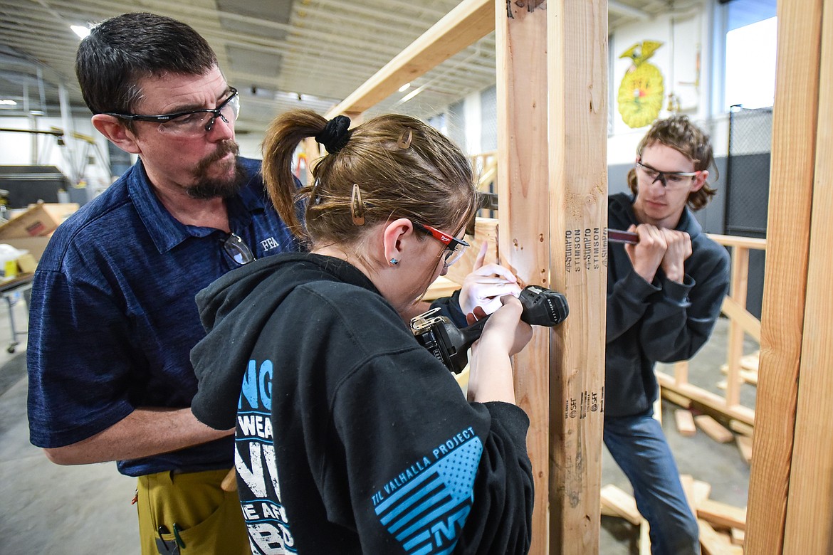 Instructor Brian Bay helps Glacier High School juniors Hailey Kopchinsky and Preston Richardson as they straighten out a header on the outer frame of their shed at the H.E. Robinson Agricultural Education Center in Kalispell on Wednesday, March 2. (Casey Kreider/Daily Inter Lake)