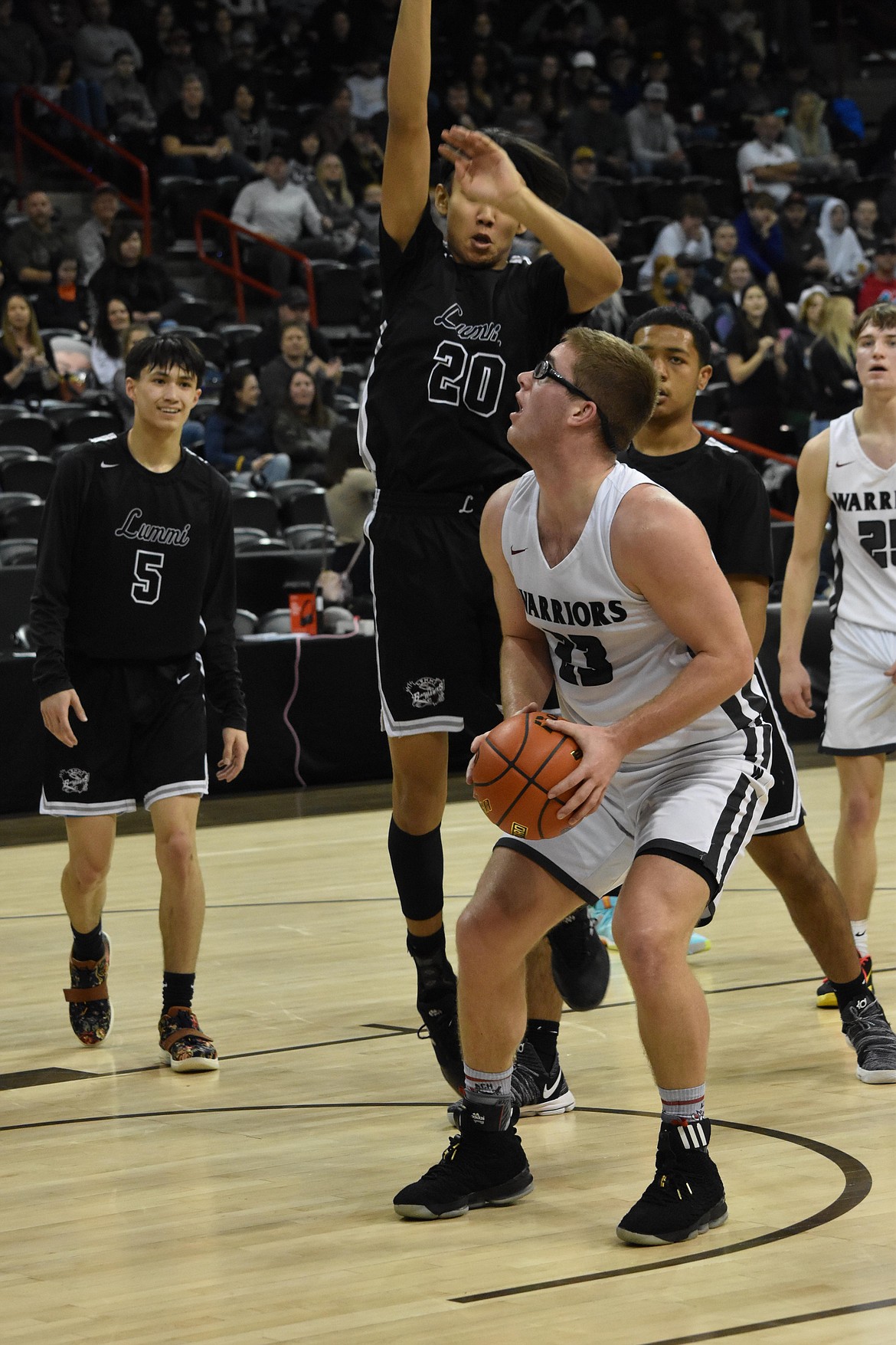 ACH senior Reece Isaak (23) looks to the basket as an opponent jumps to block the shot at the WIAA 1B boy state basketball tournament against Lummi Nation.
