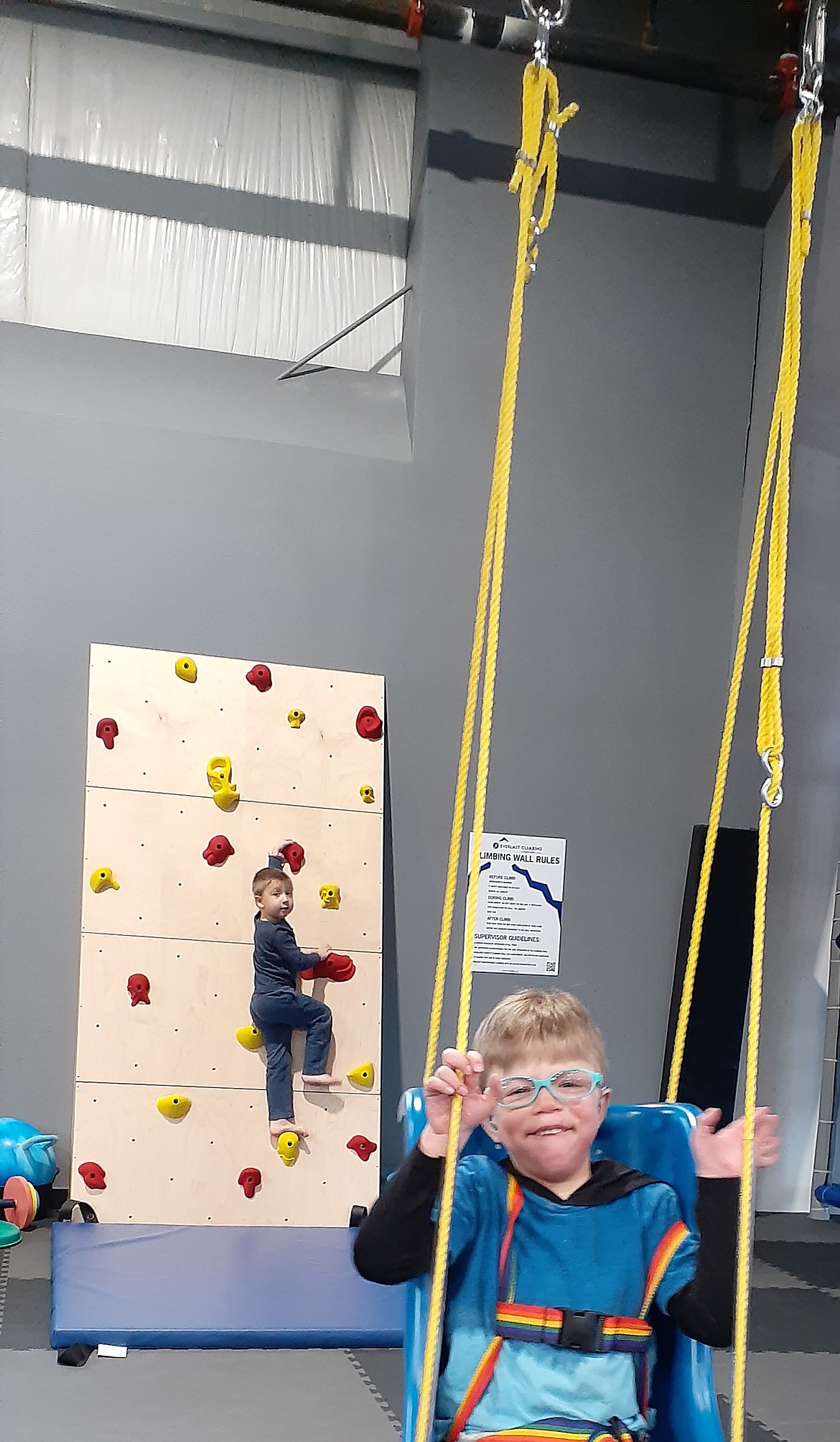 Caleb Bult, pictured in the front, and his brother, Owen, pictured on climbing wall have fun at UCAN (Unique Center for Athletes of All Needs).