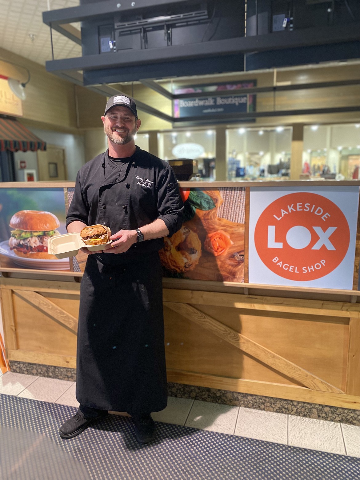 Chef Casey Fassler holding "The Texan" bagel from the Lakeside Lox bagel shop.