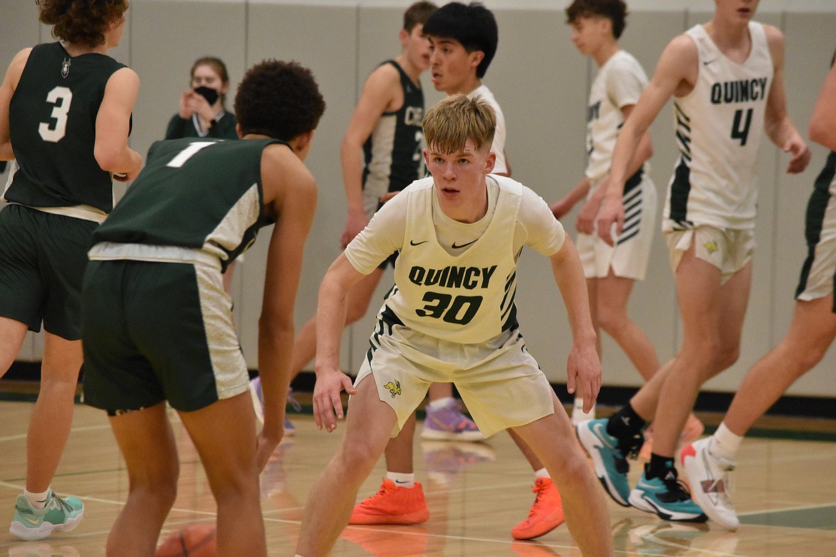 Quincy High School senior Aidan Heikes (30) stares down Chelan High School senior Nate Harding (1) as he brings the ball down court at the league matchup on Jan. 25.