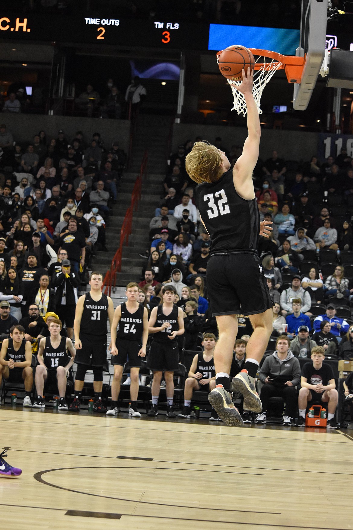 ACH senior Cooper Correia (32) makes a layup during the championship game against Cusick on March 5, as his teammates watch from the bench.