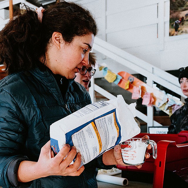 Photo by Elli Oba, North Idaho College
NIC student Hannah Smith measures flour to make biscuits in a Dutch oven during an Introduction to Outdoor Cooking class on Feb. 23 at NIC’s McClain Hall.