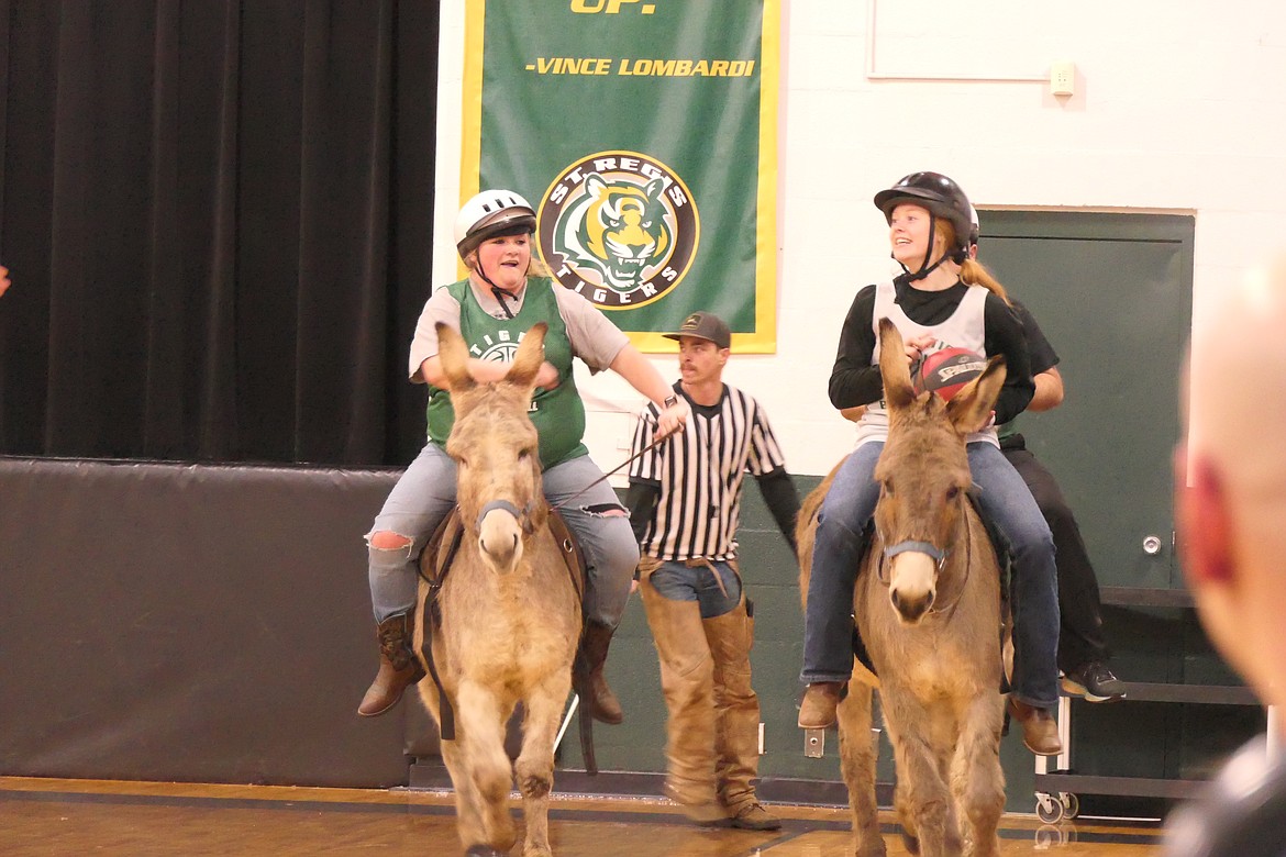 St. Regis girls basketball coach Tyler Cheesman and Tigers player Macy Hill embark on a "fast-break" donkey style during Thursday night's donkey basketball game in St. Regis.  (Chuck Bandel/MI-VP)