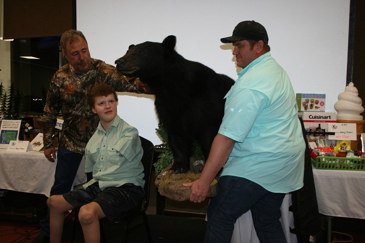 Cyrus Levine (second from right) receives his trophy from Ric Shirrod of All That’s Wild Taxidermy (right) during the annual Moses Lake banquet for Youth Outdoors Unlimited. Drew Monsey of YOU is at left. Levine received the trophy after bagging his bear in record time for a YOU participant.