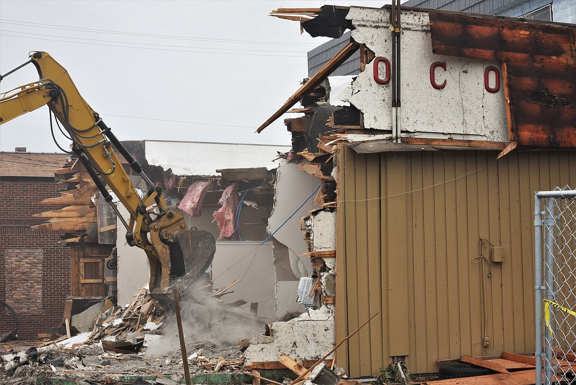 Workers from Graham Excavating demolished the building at Highway 93 and First St. East in Polson last week. During demolition, old lettering from the building's days as a gas station long ago was exposed. The site is the future home of Swimming Horse Distillery, which is expected to open this summer. (Scot Heisel/Lake County Leader)