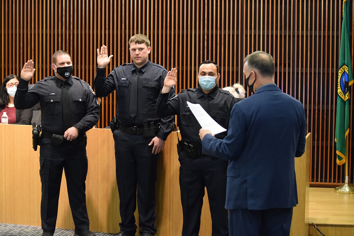 Moses Lake Police Chief Kevin Fuhr (right) swears in newly promoted or hired Moses Lake Police (from left to right) Sgt. Aaron Hintz and officers Nicholas Metcalf and Jose Ramirez at the start of the regular city council meeting on Tuesday. Hintz has served with the MLPD since 2006, while Ramirez comes to MLPD from Ephrata and Metcalf returns to Moses Lake after earning a bachelor’s degree from Morningside University in Sioux City, Iowa.