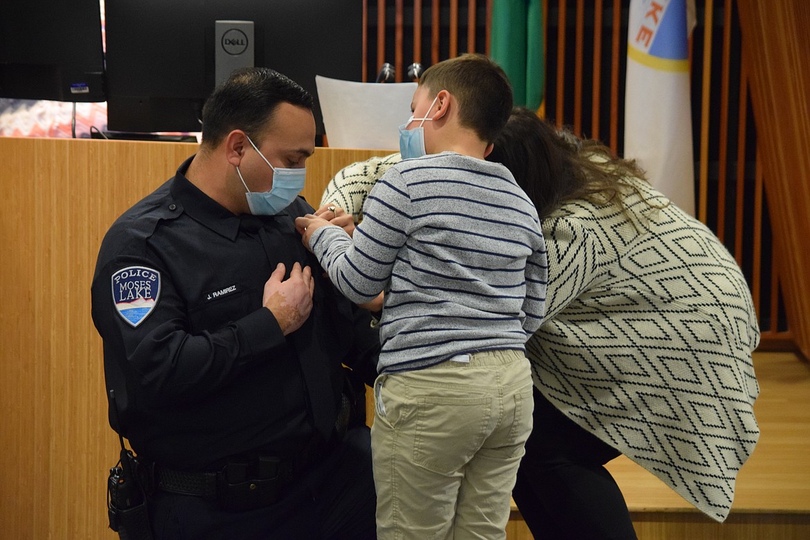 Newly sworn-in Moses Lake Police Officer Jose Ramirez has his badge pinned on by his son Xavi, 7, and his wife Rita. Ramirez, who comes to MLPD after several years serving in Ephrata, was one of three MLPD officers sworn in at a regular city council meeting on Tuesday, including Sgt. Aaron Hintz and newly commissioned officer Nicholas Metcalf.