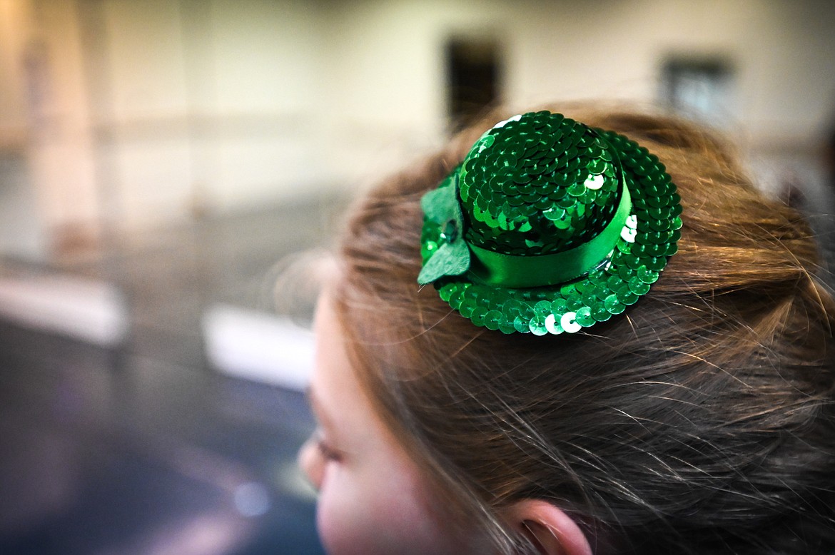 A dancer pins a small Irish hat in her hair at an An Daire Academy: Flathead Valley Irish Dance rehearsal held at the Northwest Ballet School and Company in Kalispell on Wednesday, March 9. (Casey Kreider/Daily Inter Lake)