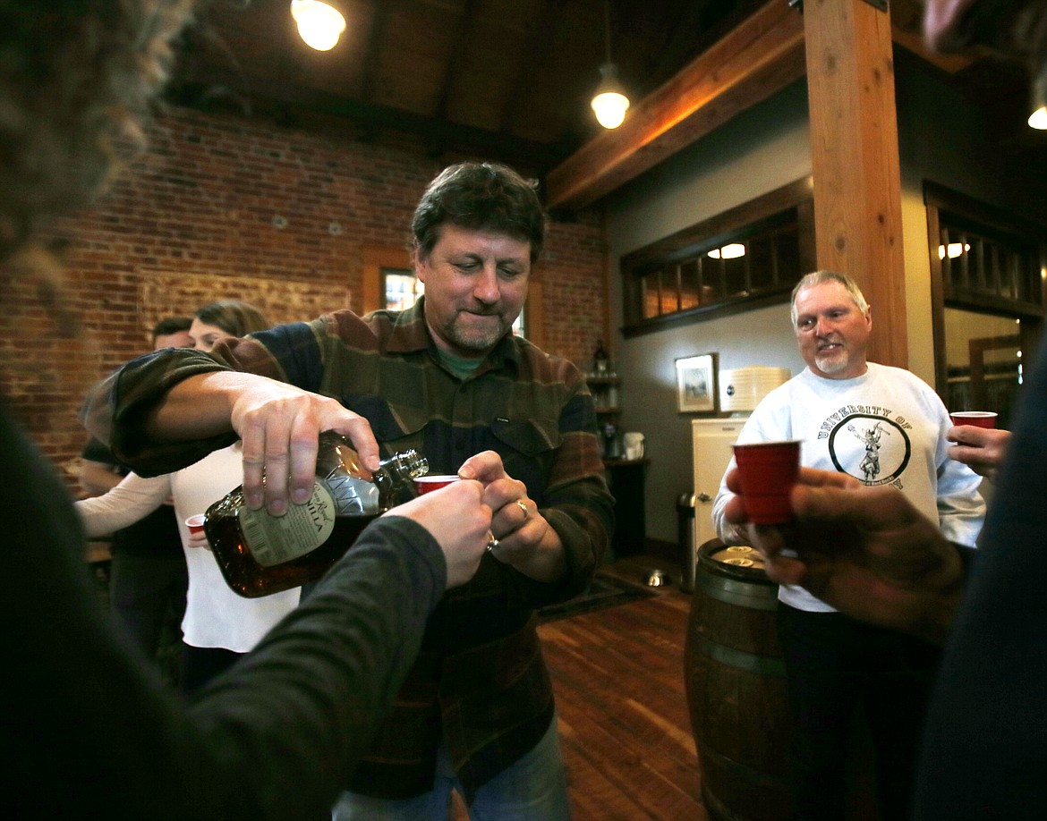 Idaho Strategic Resources CEO/President John Swallow pours a cup of cheer during a toast Friday in the company headquarters in downtown Coeur d'Alene.