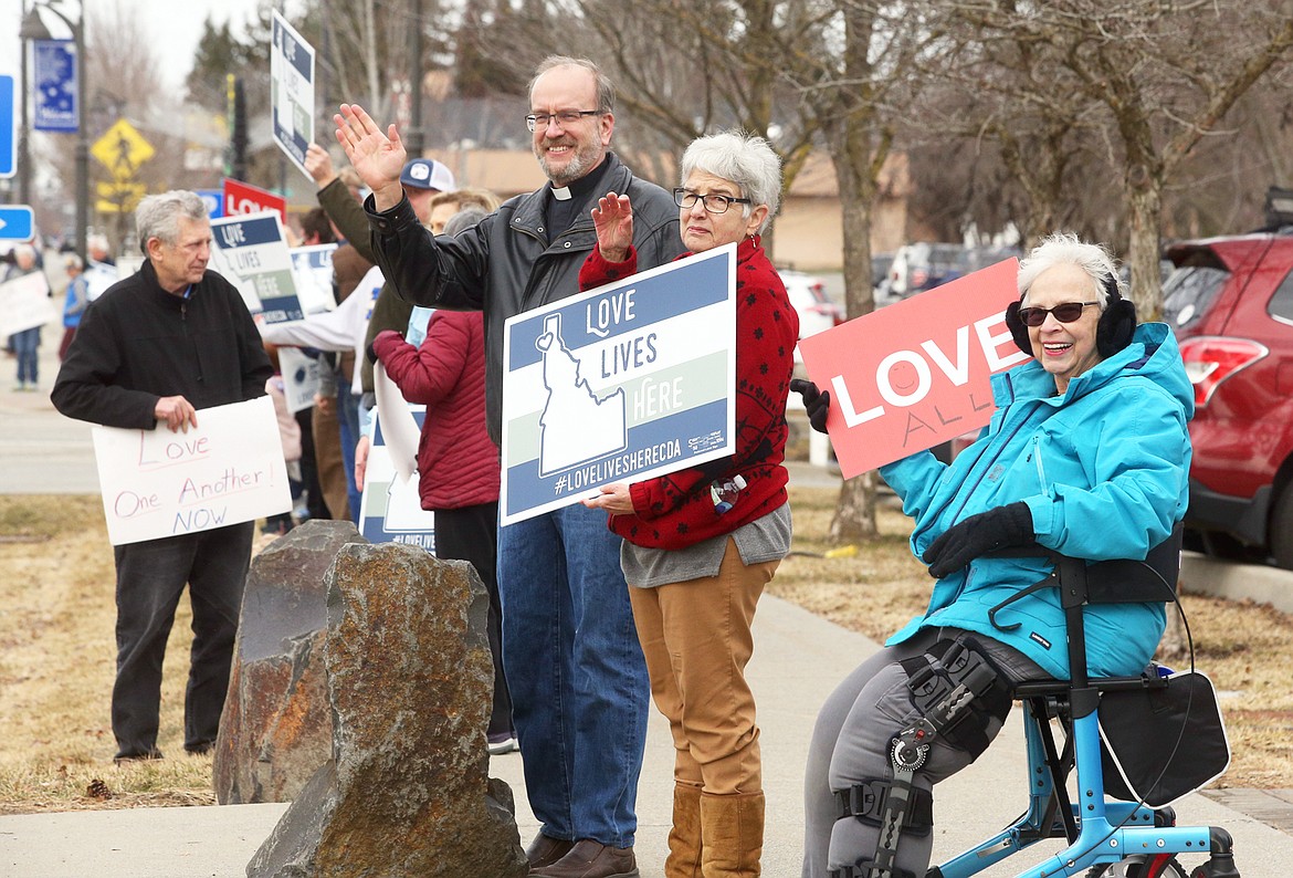 Jane Nelson, right, Jill Kalberg and the Rev. David Gortner wave to passersby during the "Love Lives Here" rally in Hayden on Saturday.