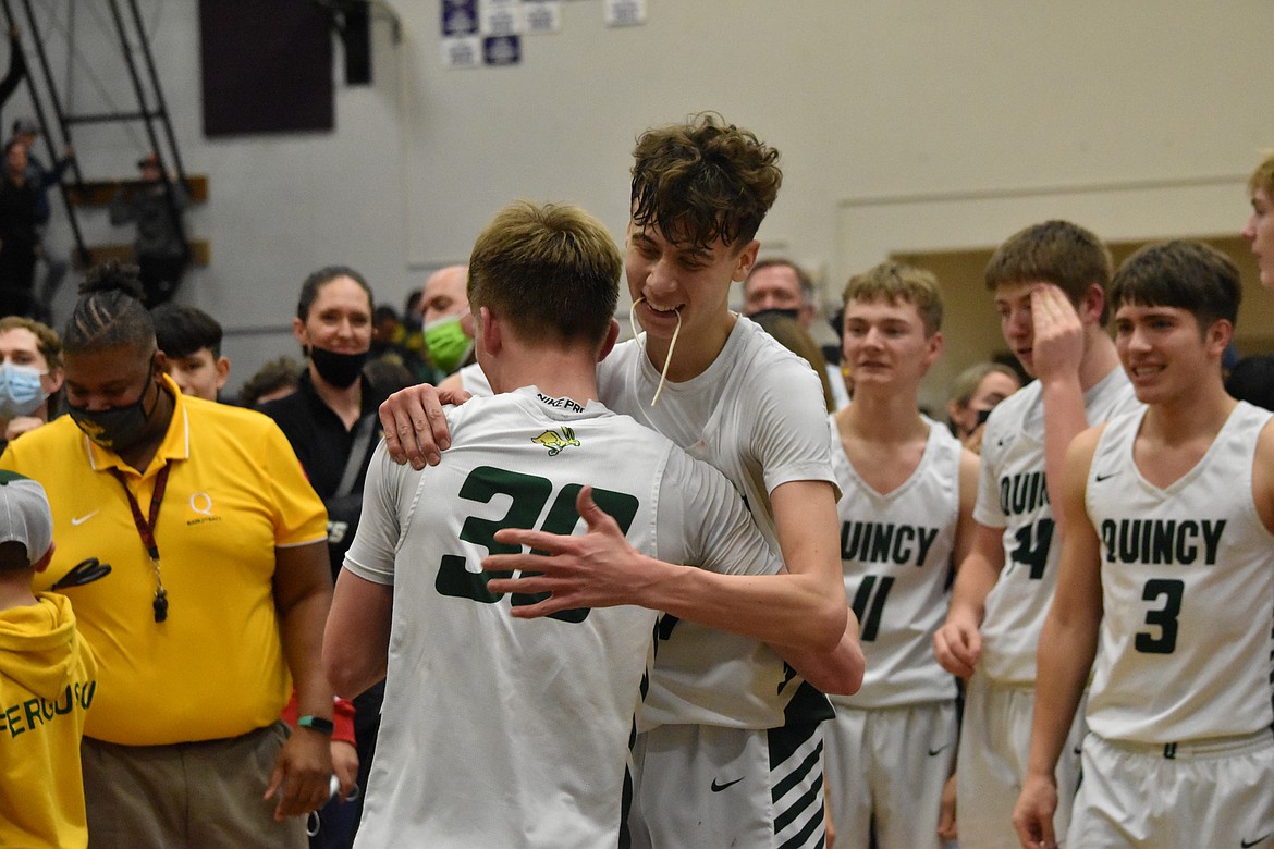 Aidan Heikes (left) and TreyVaughn Bierlink (right) hug after cutting the net on Feb .11 after winning the district championship.