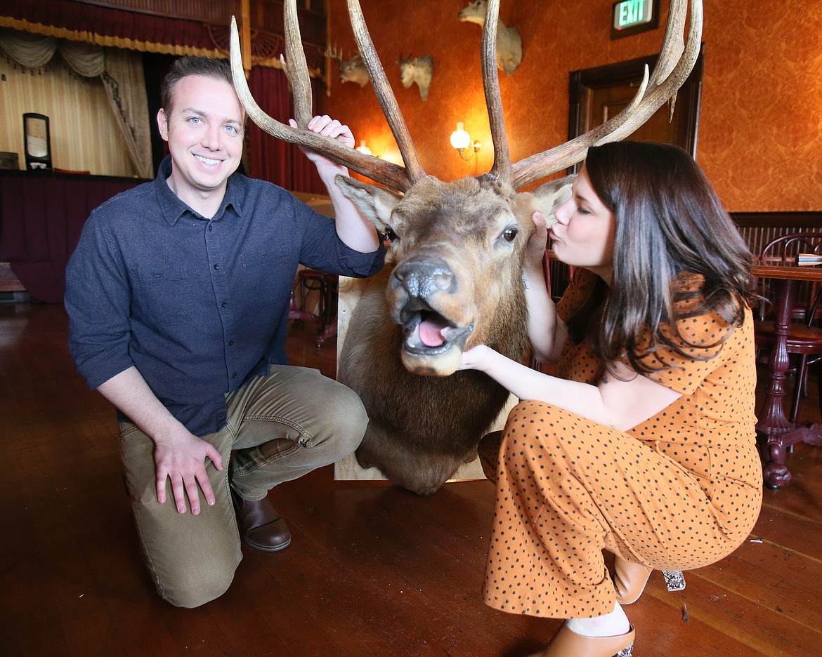 Luke and Wendi Yellin embrace their newfound North Idaho surroundings as Wendi lands a smooch on an elk mount that will be in Silverwood's High Noon Saloon.