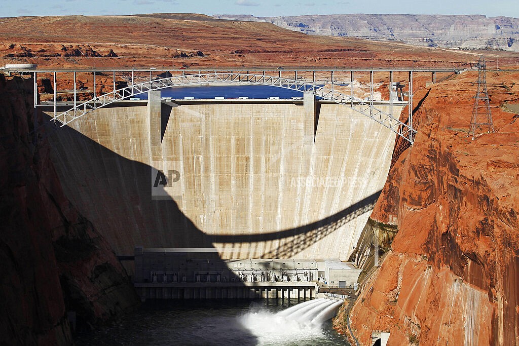 In this Nov. 19, 2012, file photo, water is released into the Colorado River at the Glen Canyon Dam in Page, Ariz. The elevation of Lake Powell fell below 3,525 feet (1,075 meters), a record low that surpasses a critical threshold at which officials have long warned signals their ability to generate hydropower is in jeopardy. (Rob Schumacher/The Arizona Republic via AP, File)