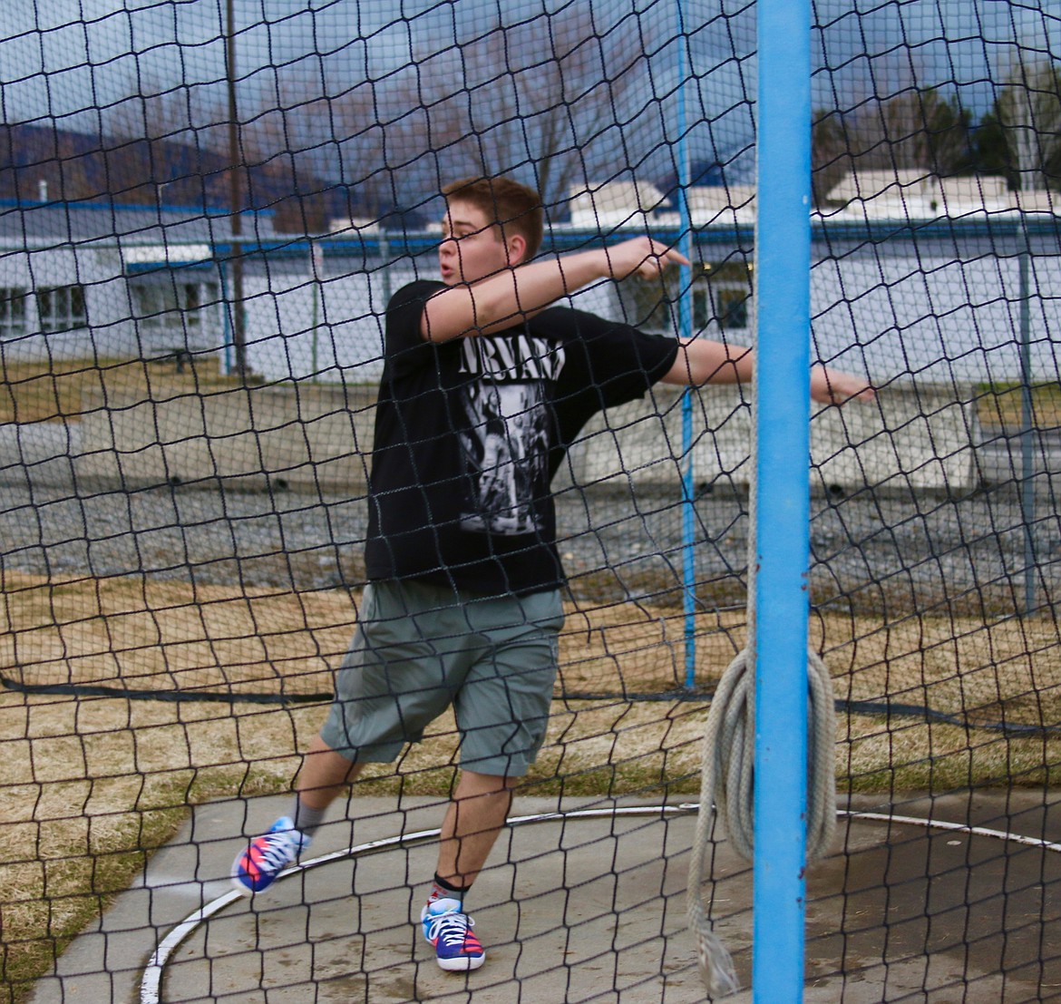 Discus thrower practices works through his throwing technique at track practices.