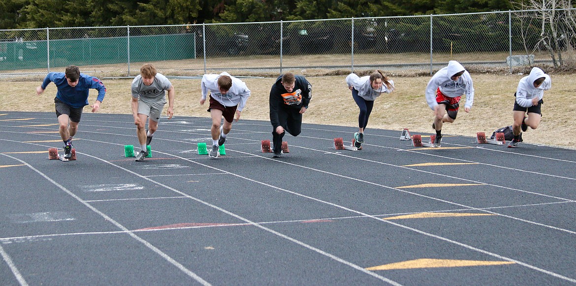 Sprinters practice using the starting blocks at track practice.