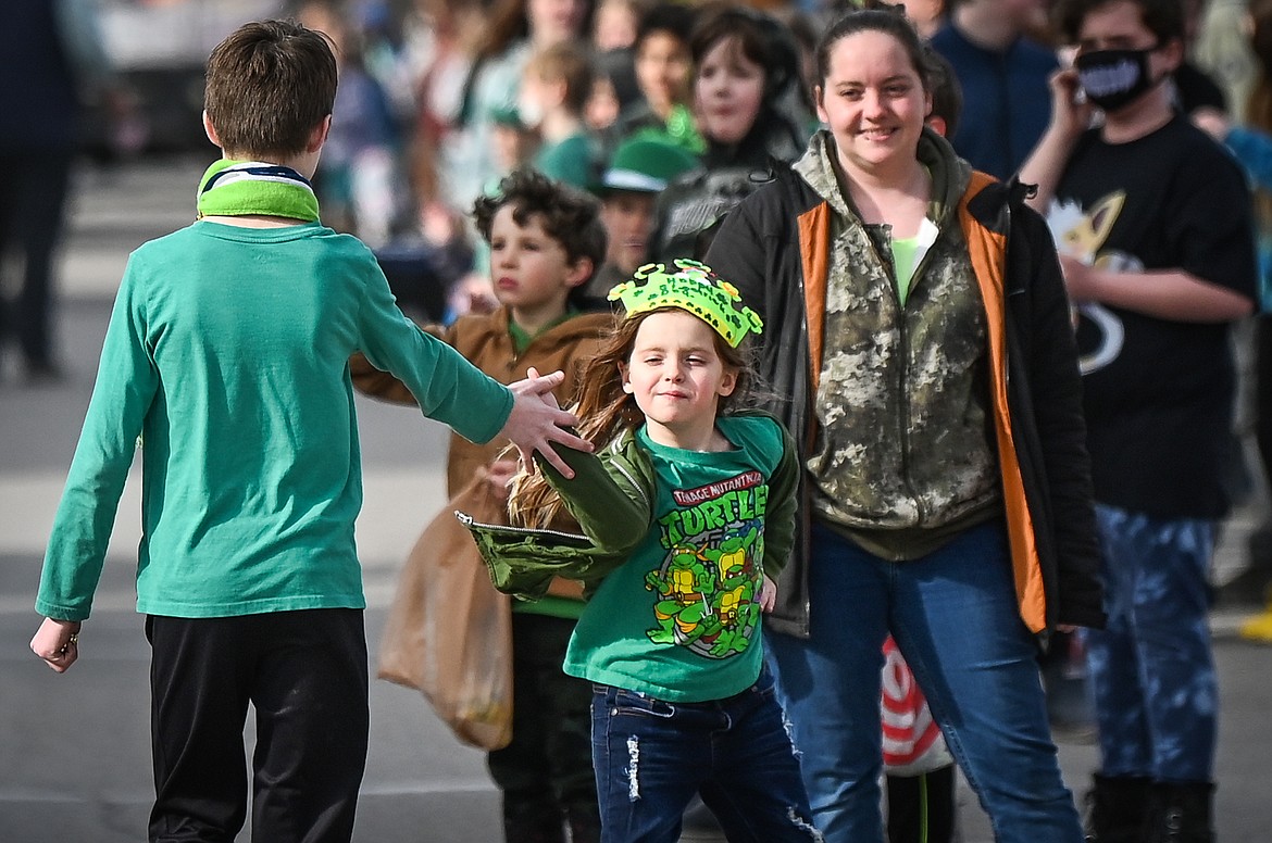 A child high-fives a parade participant during the St. Patrick's Day Parade in Kalispell on Thursday, March 17. (Casey Kreider/Daily Inter Lake)