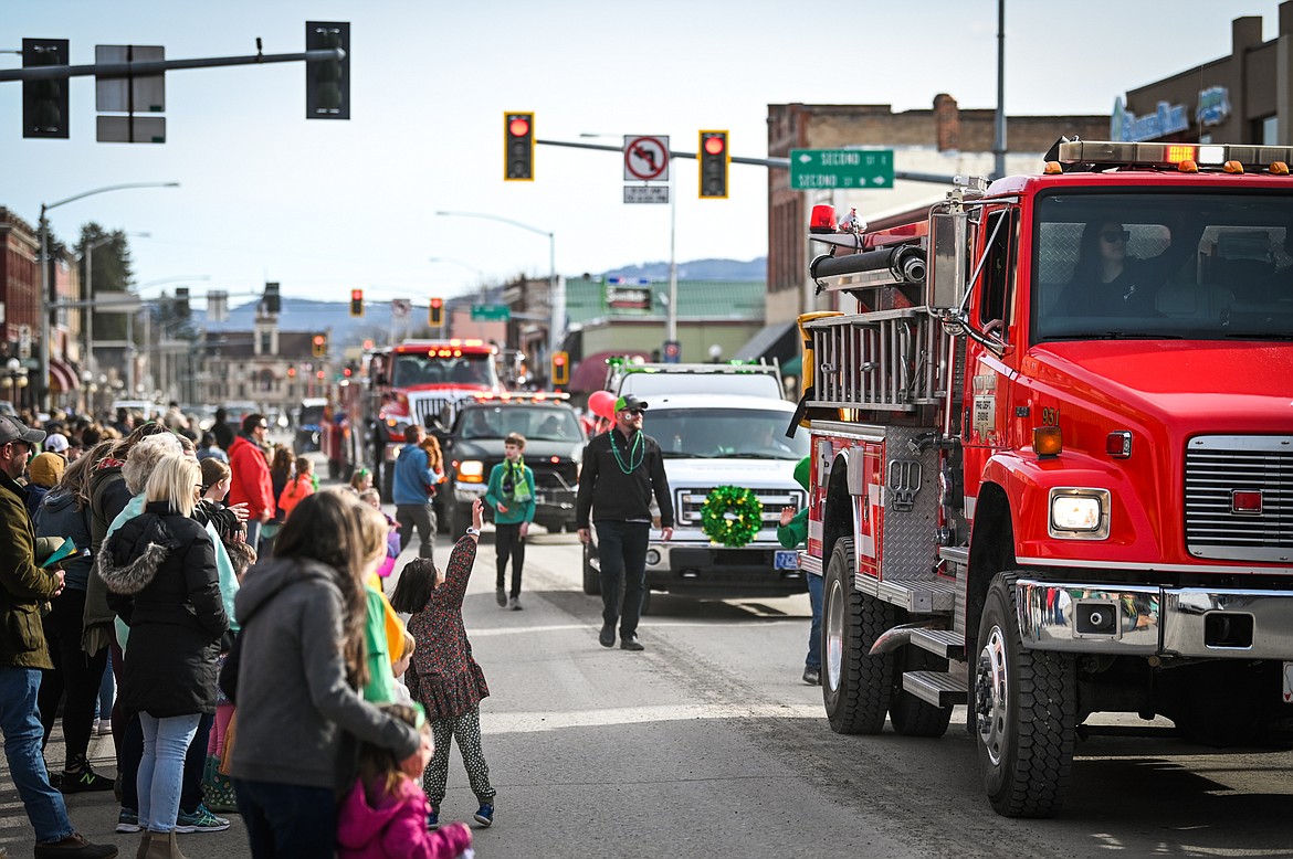 Spectators watch a line of vehicles pass during the St. Patrick's Day Parade in Kalispell on Thursday, March 17. (Casey Kreider/Daily Inter Lake)