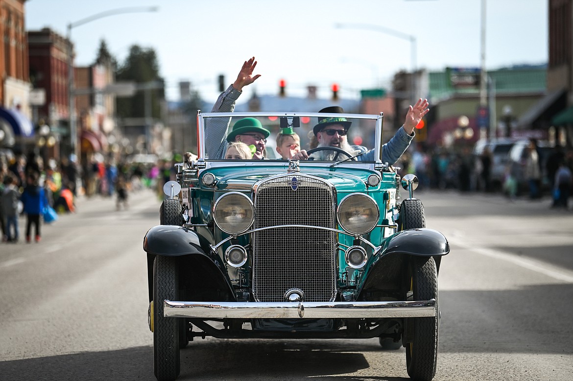 The Grand Marshall's vehicle carrying Mark and Wendy Lalum makes its way along Main Street during the St. Patrick's Day Parade in Kalispell on Thursday, March 17. (Casey Kreider/Daily Inter Lake)