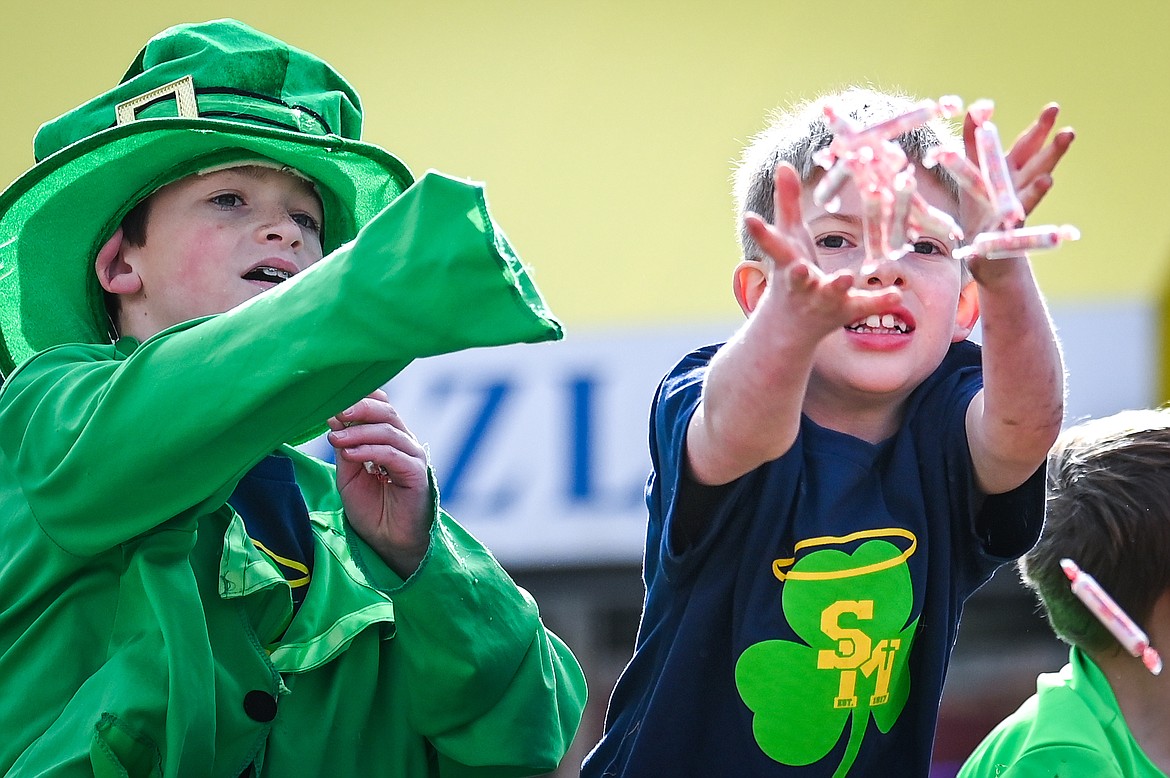 Children from St. Matthew's Catholic School toss candy to spectators during the St. Patrick's Day Parade in Kalispell on Thursday, March 17. (Casey Kreider/Daily Inter Lake)