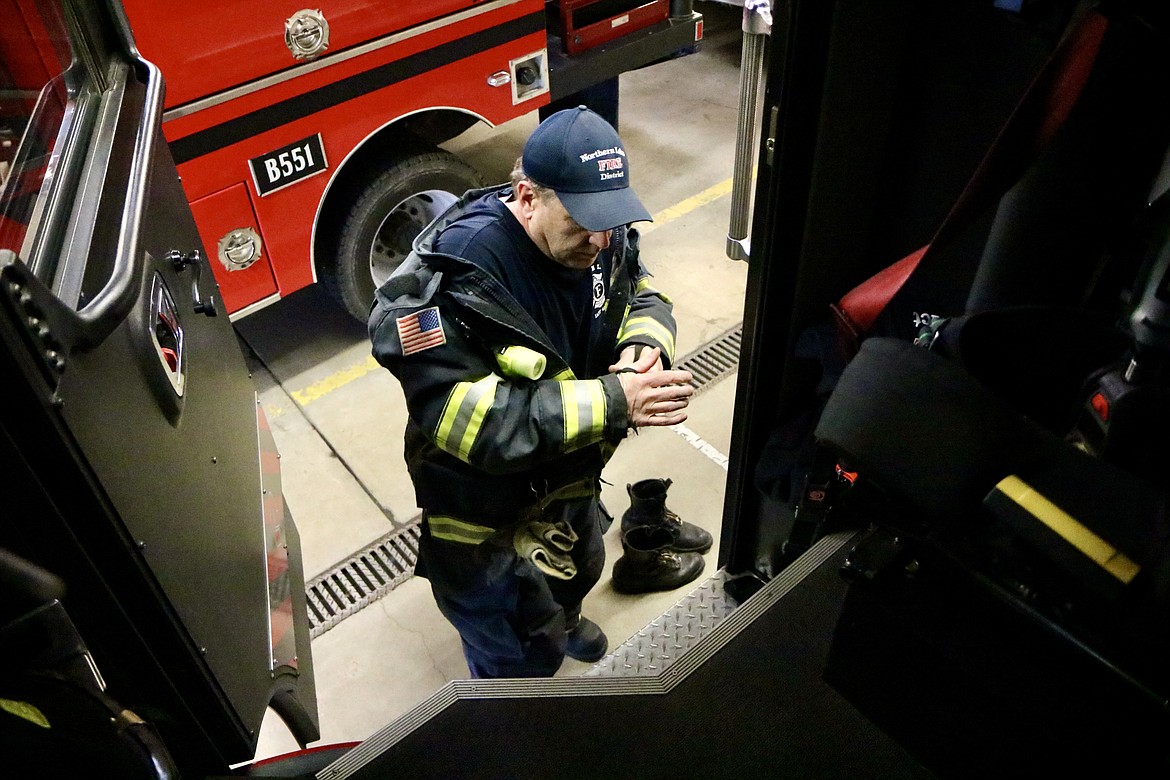 Northern Lakes Fire Protection District engineer Mike Duke, serving as fire captain because of staffing shortages, removes his protective gear after returning from a call on Wednesday. HANNAH NEFF/Press