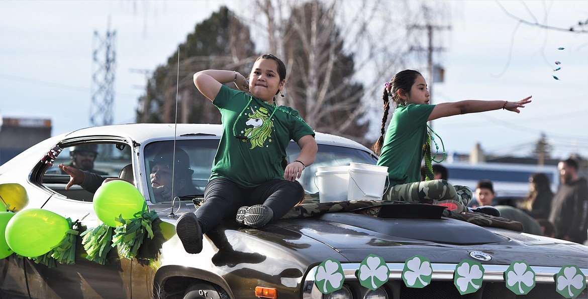 Spokane Conko-Camel, left, and Koda Irvine throw candy from the hood of Tracey Burland's car as Camas Assiniboine tosses some from the passenger's seat. (Scot Heisel/Lake County Leader)