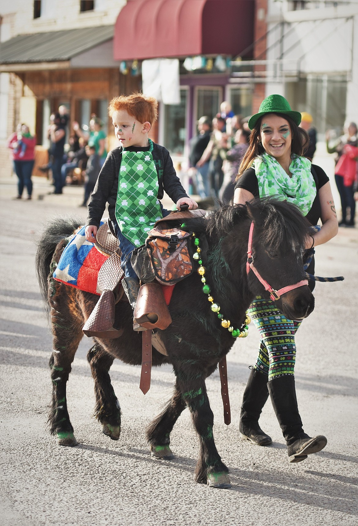 Zjani Futrell leads a pony with a young passenger down Main Street. (Scot Heisel/Lake County Leader)