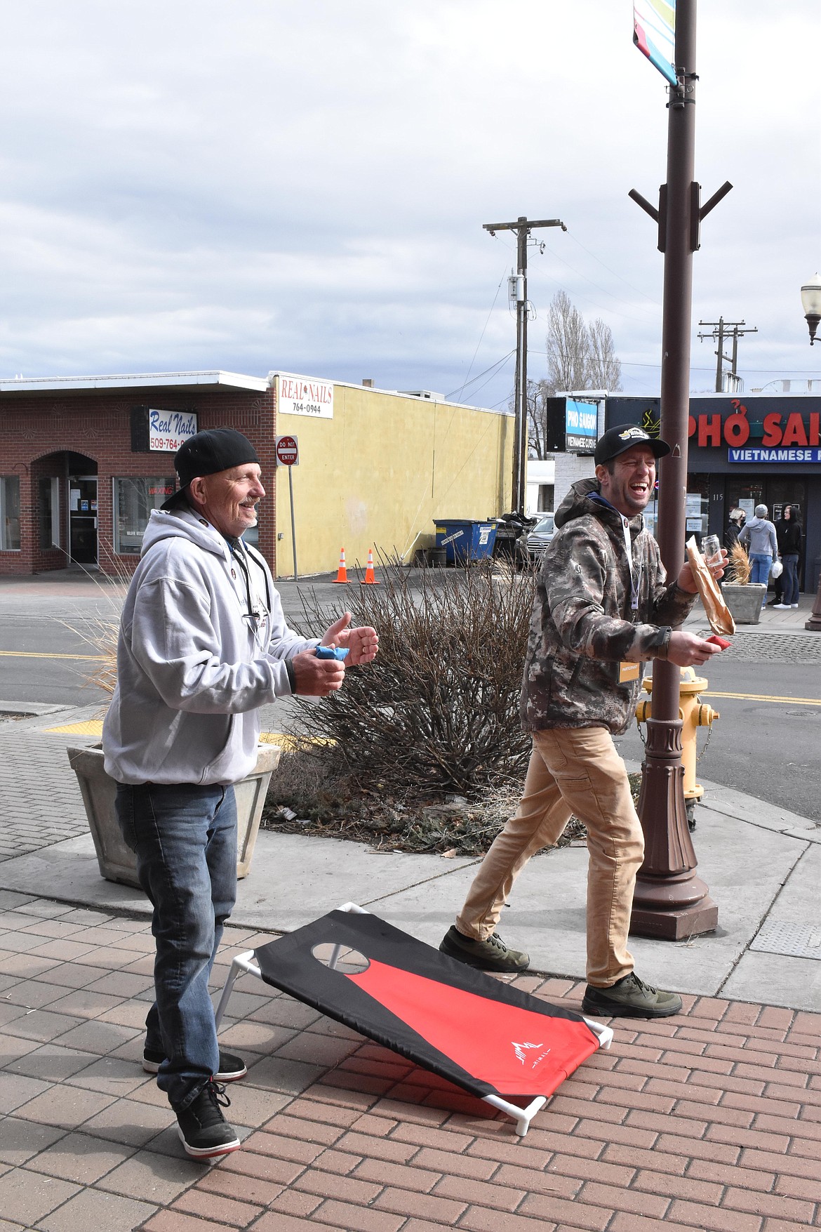 Tom and Eric Nibarger, from Coulee City, had a blast playing cornhole at one of the games set up outside the Brews & Tunes participating businesses on March 19.