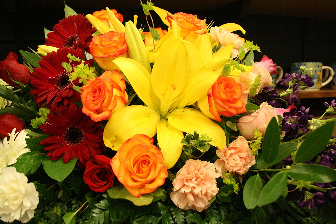 Yellow lilies and orange-tinted roses take the lead in a design by the staff at Desert Rose Floral Designs in Othello.