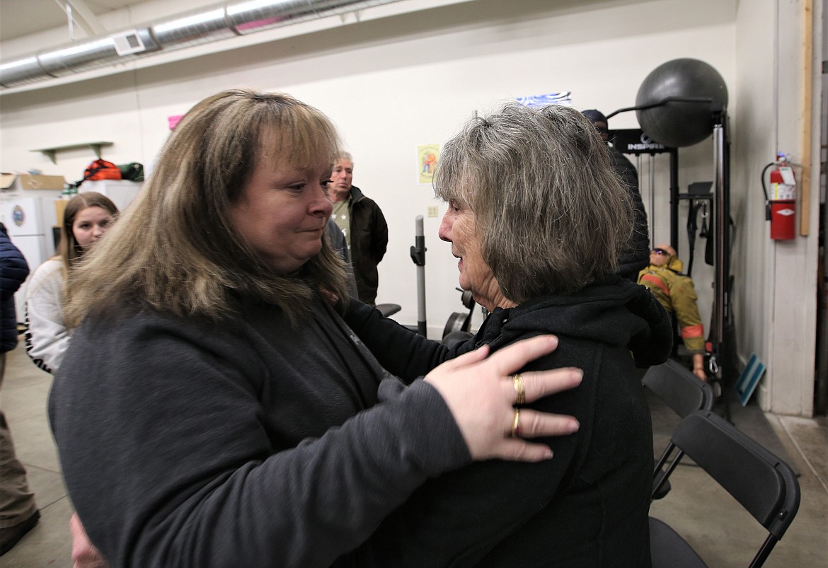 Karen Kubani and Joanne Rogers share a moment together following Monday's town hall meeting at the Hauser Lake Fire Station.