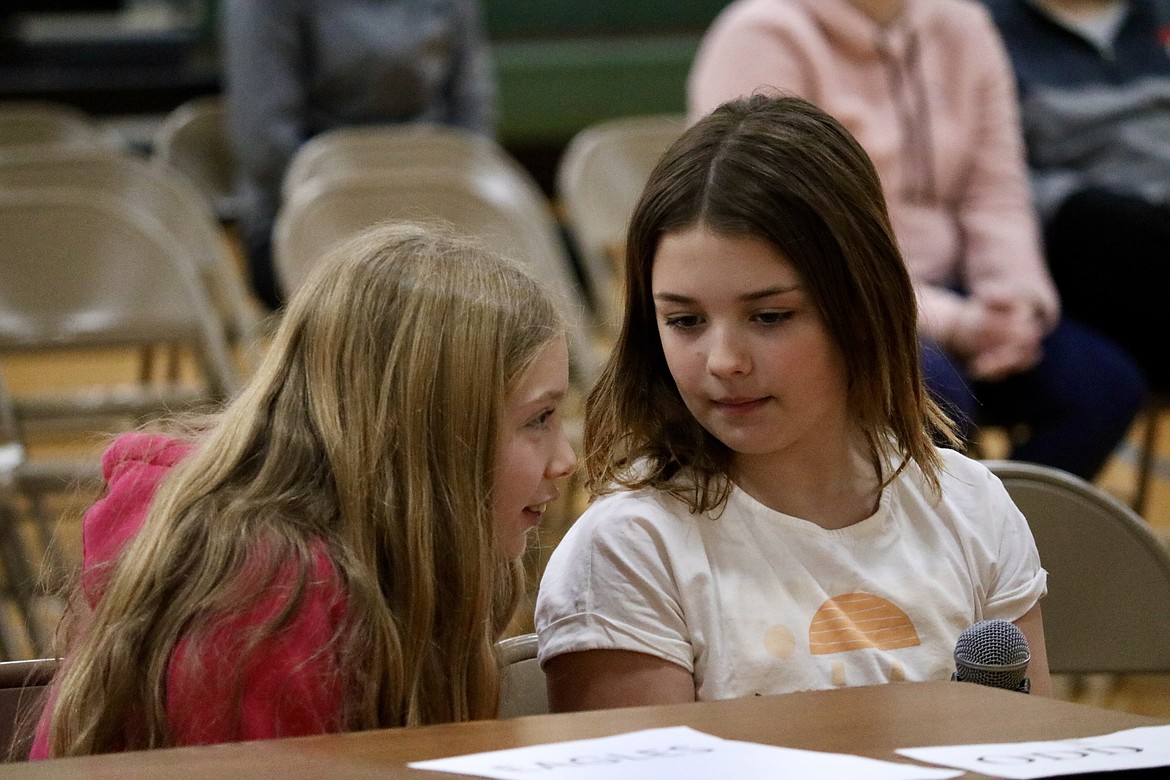 Teammates and third-graders Ariana Leferink and Halle Hatfield confer during the Battle of the Books reading comprehension bowl at Altas Elementary School on Monday. HANNAH NEFF/Press