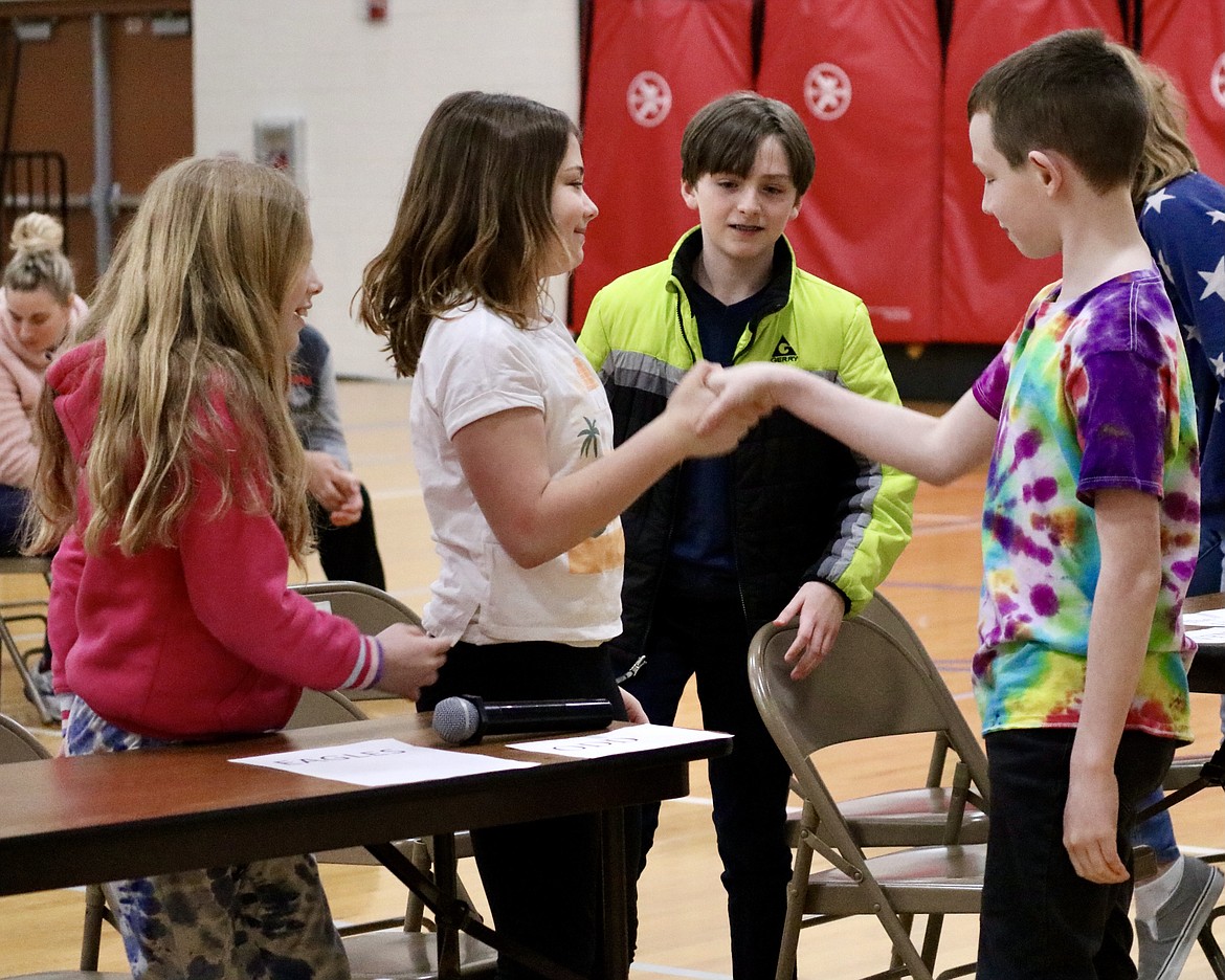 Members of the winning fifth and fourth grade teams shake hands after competing against each other for the school-wide championship in the Battle for the Books reading comprehension bowl at Atlas Elementary School on Monday. HANNAH NEFF/Press