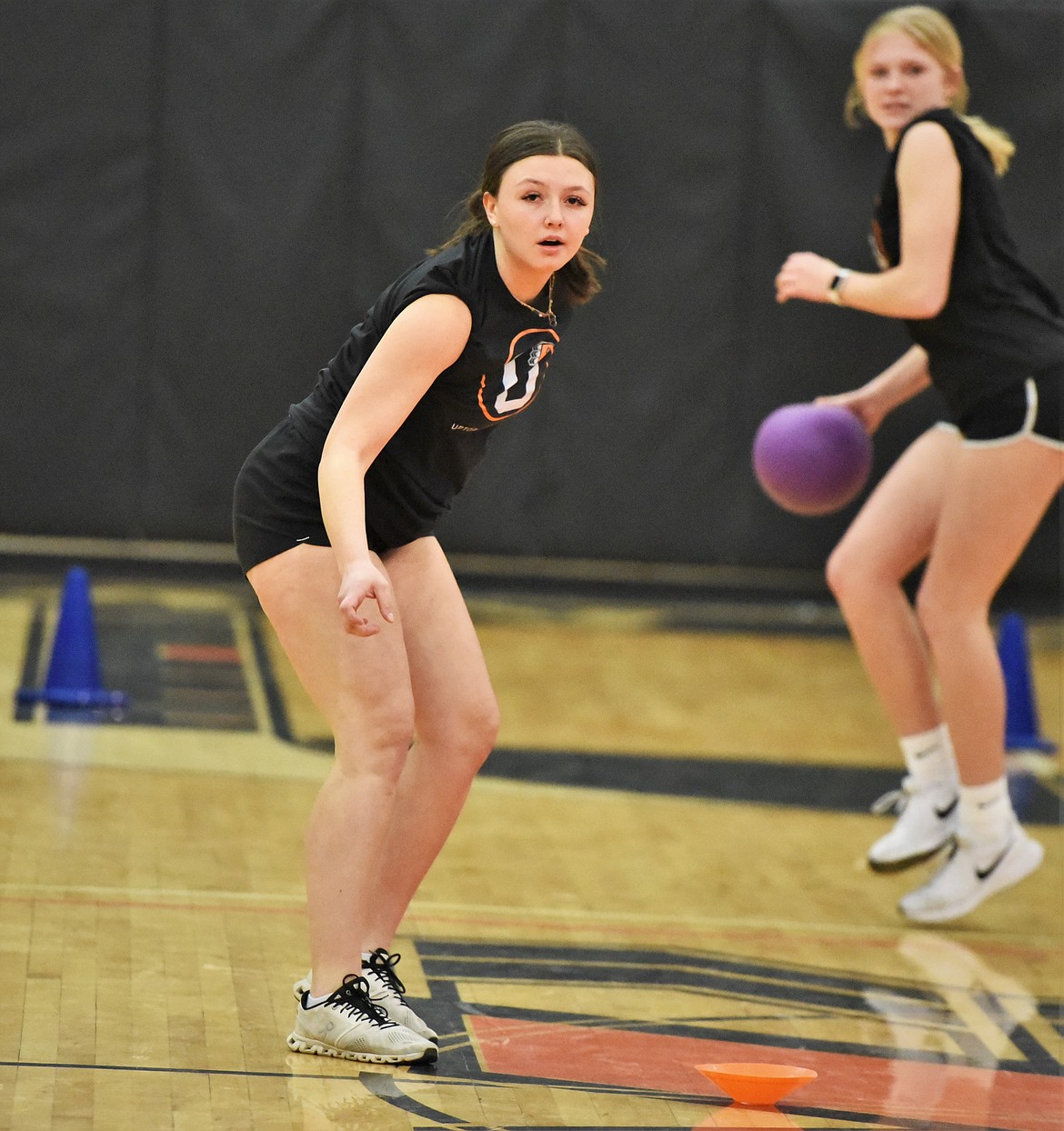 Rylie Lindquist watches her shot as Lauryn Buhr winds up in the background. They competed for the Ronan High School track and field team.(Scot Heisel/Lake County Leader)